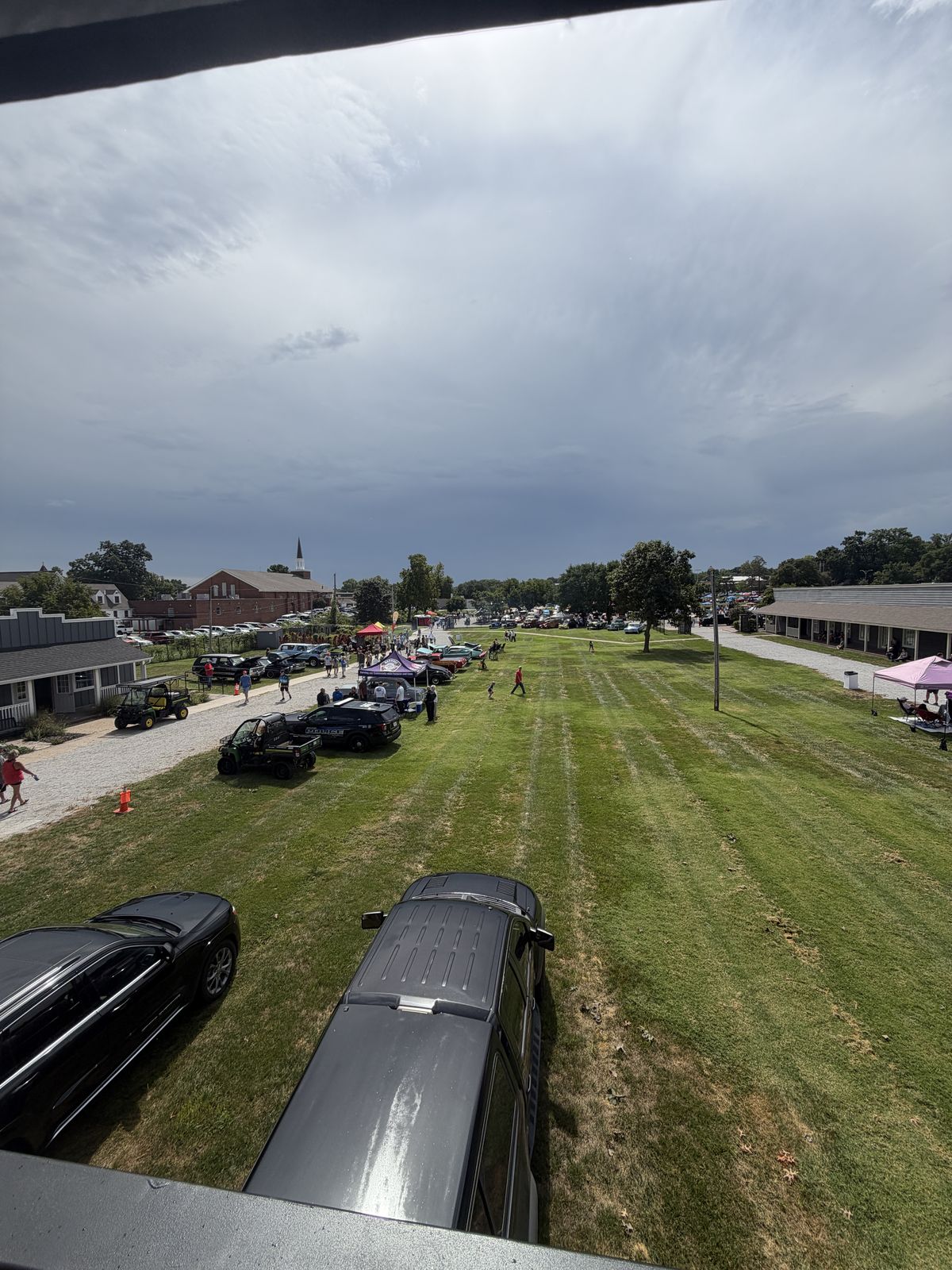 Interior of the lounge during the Shawnee car show, with the open bay framing the field
