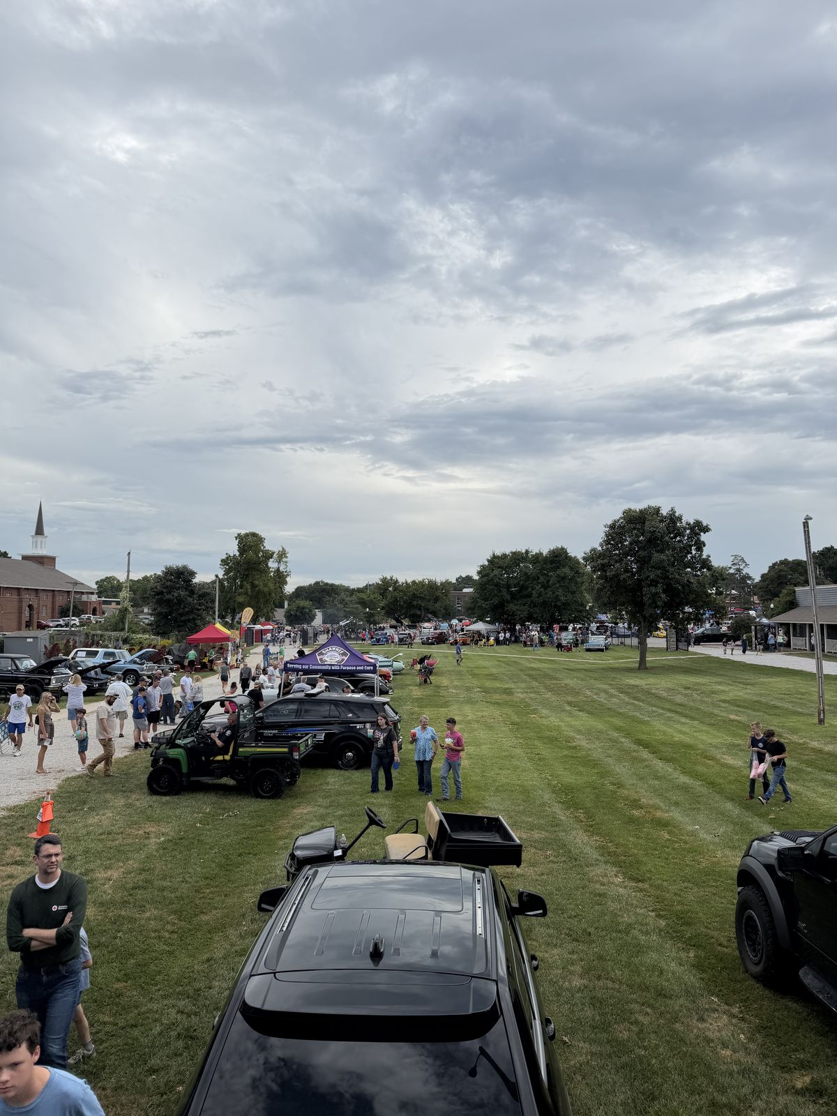 The Rolling Lounge sign on the trailer with the Shawnee car show behind it