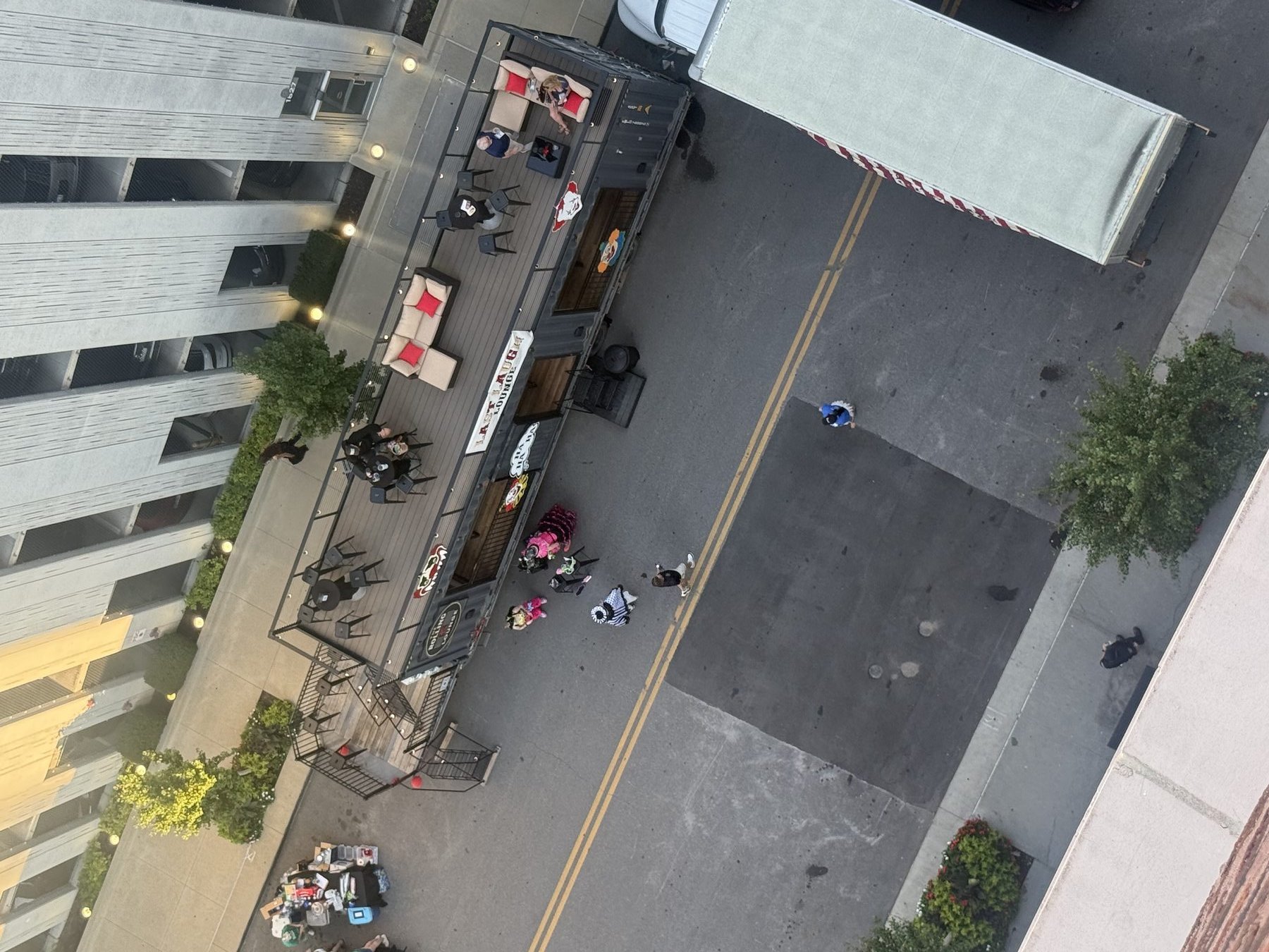 High-angle view of the lounge during a themed downtown event, with guests on the rooftop and street