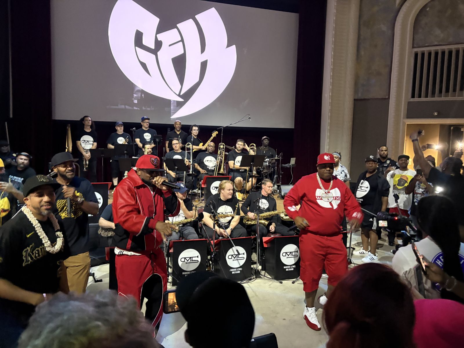 Wu-Tang performers on stage with a crowd gathered in front of the Rolling Lounge