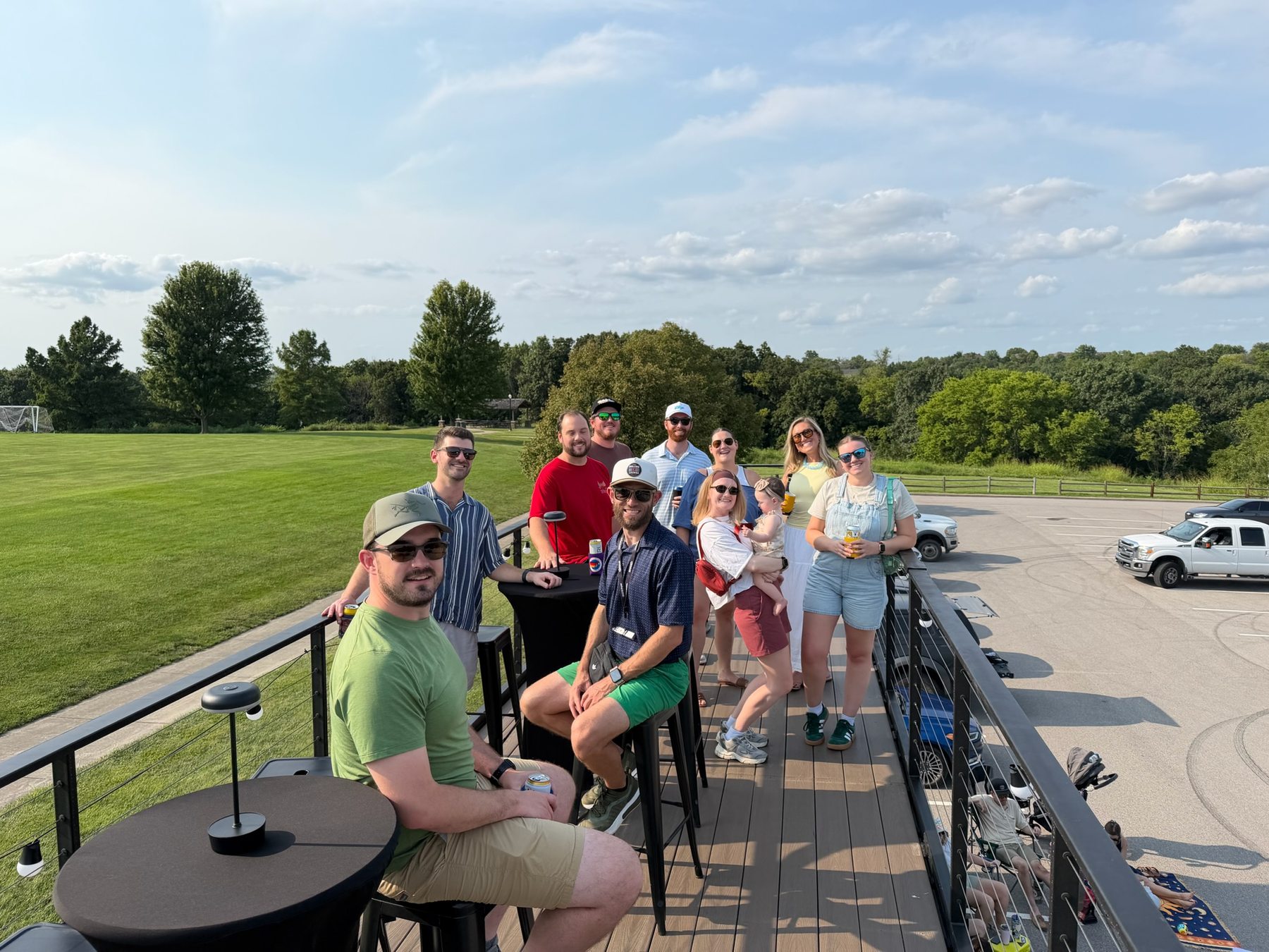 Friends posing together on the rooftop deck overlooking a green park