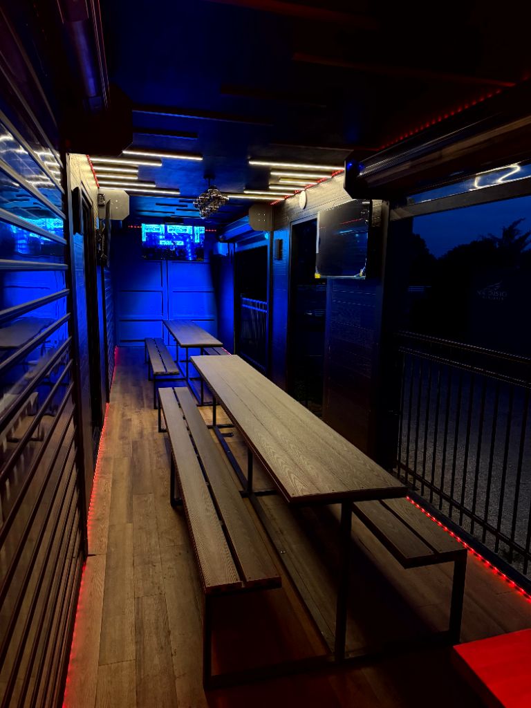 Interior dining area with long tables and cool blue lighting