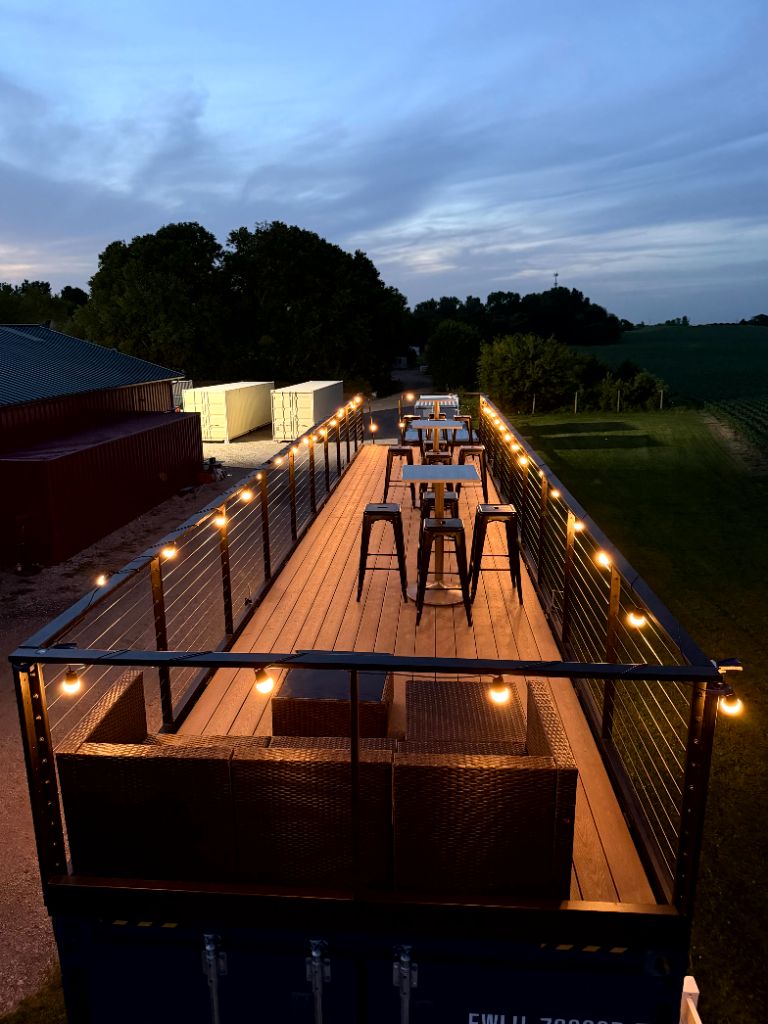 Rear rooftop deck photo at night with seating and lighting